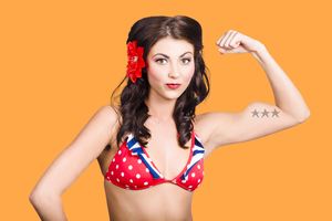 Pinup girl flexing biceps muscle. Bodybuilding