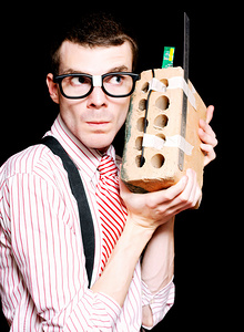 Male Nerd Inventor Holding Brick Mobile Telephone